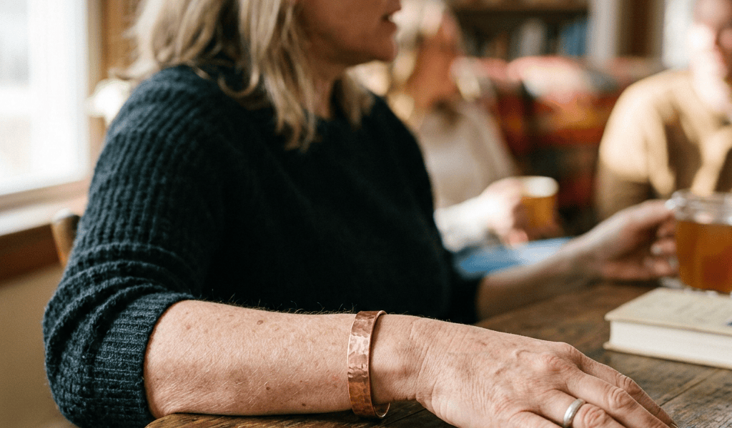 Woman seated at a café table with books and drinks nearby